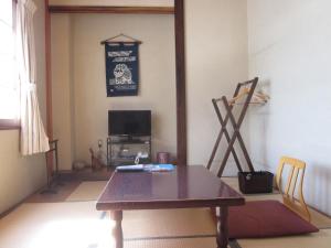a living room with a table and a television at Shiunso in Nikko