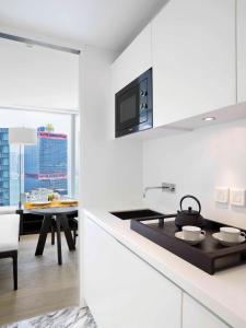 a white kitchen with a stove and a dining room at The Jervois in Hong Kong