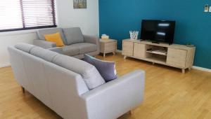 a living room with a couch and a tv at Karuah Riverside Motel in Karuah