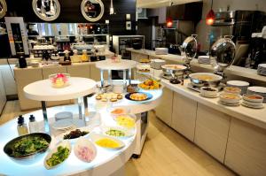 a kitchen with several tables filled with food at Grand Park Hotel Panex Tokyo in Tokyo