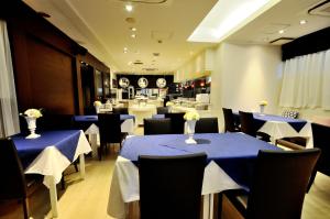 a dining room with blue tables and chairs and a restaurant at Grand Park Hotel Panex Tokyo in Tokyo