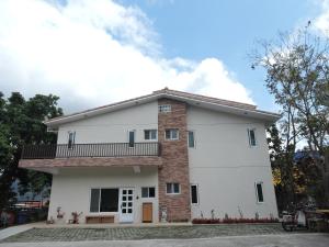 a house with a balcony on top of it at Deer House in Yongan