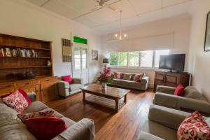 a living room with couches and a tv at Pooles Rock Vineyard Accommodation in Pokolbin
