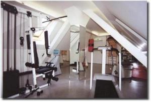 um quarto amplo com um ginásio com uma passadeira em Hotel Gasthof zur Post em Munique