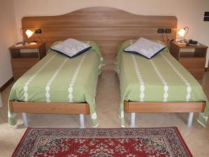 two twin beds in a room with two night stands at Locanda "Alla Rosa" in Lusiana