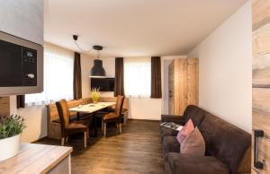 a living room with a couch and a table at Dolomite Apartments - by Familiaris in San Candido