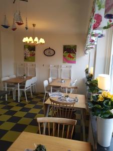 a restaurant with tables and chairs and a checkered floor at Hotell Bode in Karlshamn