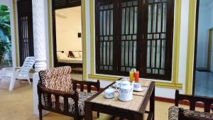 a wooden table with two chairs and a table with food on it at Yala Southern Retreat in Tissamaharama