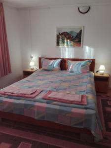 a bedroom with a large bed with two lamps at Villa Jun Guest House in Belogradchik