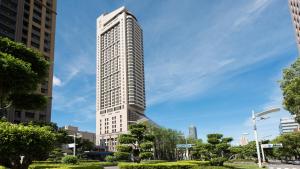 a tall white skyscraper in a city at Han Hsien International Hotel in Kaohsiung