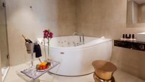 a bathroom with a white tub and a bottle of champagne at Hotel Palacete de Alamos in M&aacute;laga