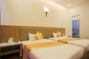 una camera d'albergo con due letti e una finestra di Red Palace Hotel a Da Nang