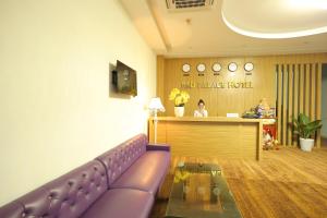 a waiting room with a purple couch in front of a counter at Red Palace Hotel in Da Nang