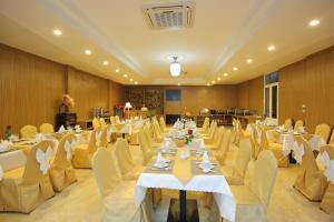 una sala banchetti con tavoli bianchi e sedie gialle di Red Palace Hotel a Da Nang