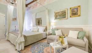 um quarto de hotel com uma cama e um sofá em Vecchia Verona Rooms & Apartments em Verona
