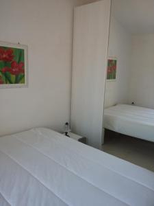 パキーノにあるCasa vacanze a Pachinoのベッドルーム(白いベッド1台、鏡付)