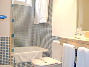 a bathroom with a white toilet and a sink at Hotel Murrieta in Logroño