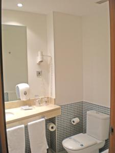 a bathroom with a toilet and a sink and a mirror at Hotel Murrieta in Logroño