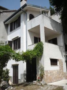 a white building with a black door in front of it at Apartments Kupine in Bol