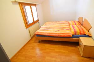 Bett in einem kleinen Zimmer mit Fenster in der Unterkunft The River Holiday Apartment in Interlaken