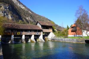 a bridge over a river next to a mountain at The River Holiday Apartment in Interlaken