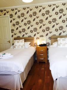 a bedroom with two beds and a wall at The Crown Hotel in Peebles