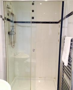 uma casa de banho com uma cabina de duche em vidro e um lavatório. em The Crown Hotel em Peebles