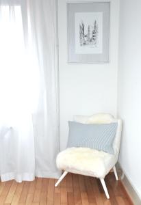 ルツェルンにあるCozy Apartment Ulmenstrasseの窓付きの客室で、白い椅子が備わります。