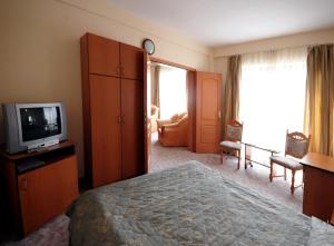 トゥルグ・ムレシュにあるHotel Everestのベッドとテレビが備わるホテルルームです。
