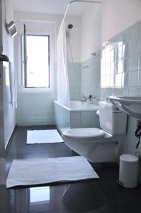 a bathroom with a toilet and a sink and a tub at Cozy Apartment Ulmenstrasse in Lucerne