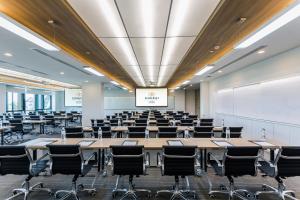 a conference room with tables and chairs and a projection screen at Somerset Ekamai Bangkok in Bangkok +78 photos
