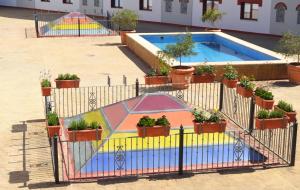 a fence with potted plants next to a pool at Hotel Reyes Ziries in Albolote