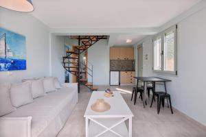 a living room with a white couch and a table at Alati Apartments in Paralía Sergoúlas