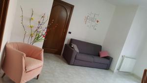 ein Wohnzimmer mit einem Sofa und einem Stuhl in der Unterkunft A Casa Di Melo in Piraino