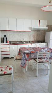 una cucina con tavolo, sedie e piano cottura di A Casa Di Melo a Piraino