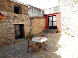 un patio avec une table et des chaises dans un bâtiment dans l'établissement Casa Rural La Perra Gorda, à Zorita