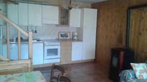 ソーリコにあるHoliday home Désiréeのキッチン(白いキャビネット、白い電化製品付)