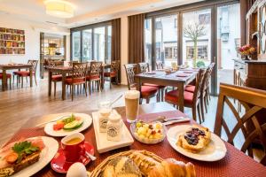 - une table avec des aliments pour le petit-déjeuner dans un restaurant dans l'établissement Weinstadt Hotel - das Original, à Weinstadt