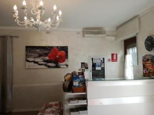 デセンツァーノ・デル・ガルダにあるHotel La Passeggiataの冷蔵庫付きのキッチン、赤い花の壁