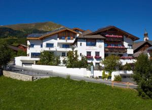 a large white building on the side of a road at Hotel am Römerweg in Fiss