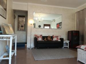 a living room with a black couch and a mirror at Hotel La Passeggiata in Desenzano del Garda
