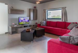 sala de estar con sofá rojo y TV en Villa 121, en Berlare