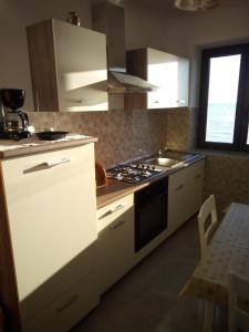 a kitchen with white cabinets and a stove top oven at Apartment Nonna Maria in Umag