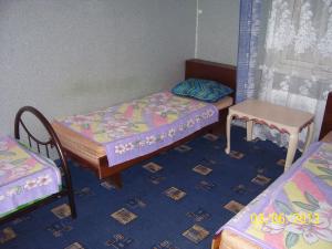 エイスクにあるDom on Moskovskayaのベッド2台とテーブルが備わる小さな客室です。