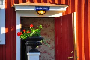 un jarrón con flores rojas delante de una puerta en Hem till Gården boutique hotel en Västerås