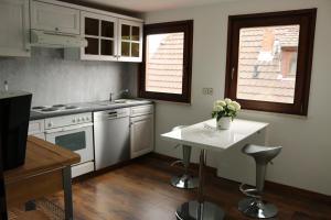 a kitchen with white appliances and a table with flowers on it at Daddy's home in Hargesheim