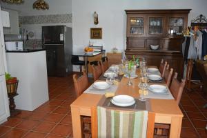 a dining room with a table with plates and glasses on it at Casa Antiquada in Albufeira