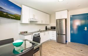 a kitchen with white cabinets and a blue refrigerator at Hamilton on Beaumont in Newcastle