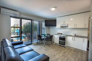 a living room with a couch and a kitchen at Hamilton on Beaumont in Newcastle