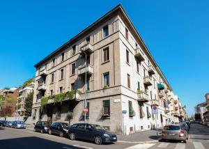 um grande edifício com carros estacionados em frente em The Best Rent - Attic Porta Romana em Milão